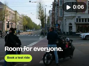 Een YouTube-bumper van zes seconden: een bakfiets in een straat in de stad onder de kop Room for everyone.